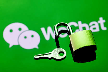 Kazan, Russia - Nov 16, 2021: An open security lock and key on the background of the WeChat...