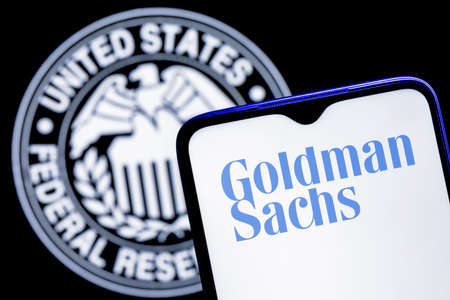 Kazan, Russia - Dec 20, 2021: Smartphone with Goldman Sachs bank logo on background of Federal Reserve symbolのeditorial素材