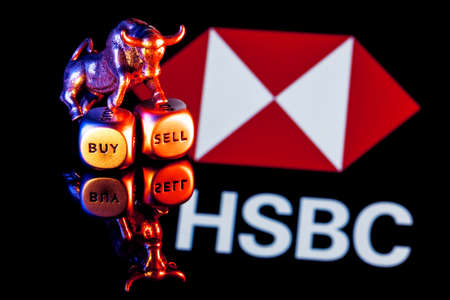 Kazan, Russia - Jan 16, 2022: Metal bull stands on buy-sell dices on background of HSBC bank logoのeditorial素材