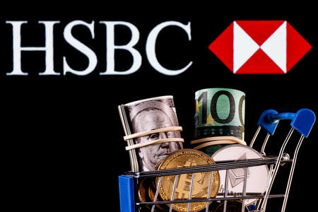 Kazan, Russia - Jan 16, 2022: Crypto and traditional currencies in shopping cart on background of HSBC bank logoのeditorial素材