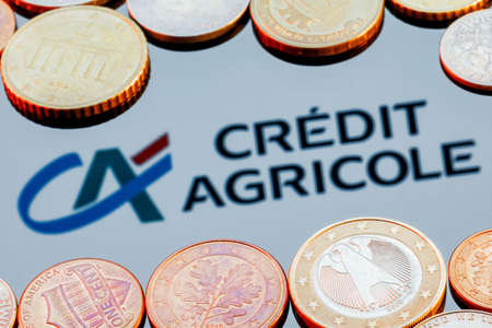 Kazan, Russia - Dec 16, 2021: Variety of metal coins on background of Credit Agricole bank logoのeditorial素材