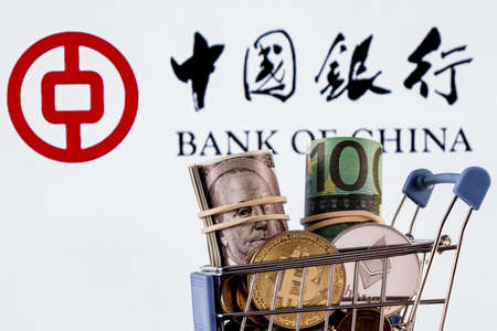 Kazan, Russia - Dec 27, 2021: Crypto and traditional currencies in shopping cart on background of Bank of China logoのeditorial素材