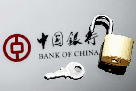 Kazan, Russia - Dec 27, 2021: An open security lock and key on background of Bank of China logo in mirror reflectionのeditorial素材