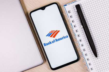 Kazan, Russia - Jan 09, 2022: Smartphone with Bank of America logo on wooden table next to laptop and business plannerのeditorial素材