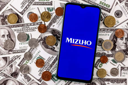 Kazan, Russia - Jan 22, 2022: Smartphone with Mizuho Financial Group surrounded by variety of metal...
