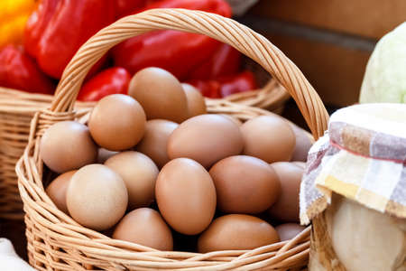Lots of eggs in a wicker basket at a village fair. Rural food and agriculture concept.の写真素材