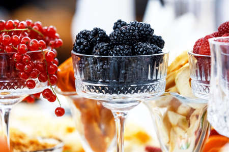 Several glasses filled with fresh berries of red currant, blackberry and raspberry. Berries of the summer garden.の写真素材