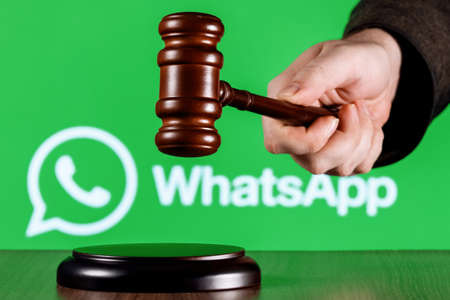 Kazan, Russia - Mar 31, 2022: Gavel in judge hand against background of Whatsapp messenger logo. The concept of trial.のeditorial素材