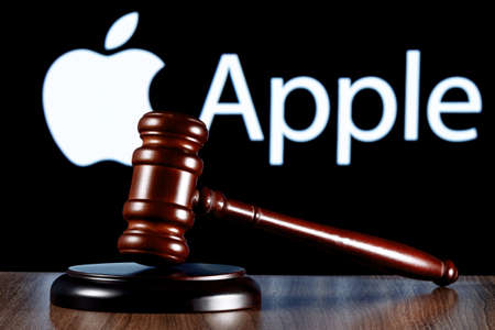 Kazan, Russia - Apr 04, 2022: Gavel on table against the background of Apple company logo. The concept of the trial.のeditorial素材