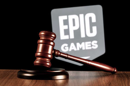Kazan, Russia - Apr 14, 2022: Gavel on table against the background of Epic Games company logo. The concept of the trial.のeditorial素材