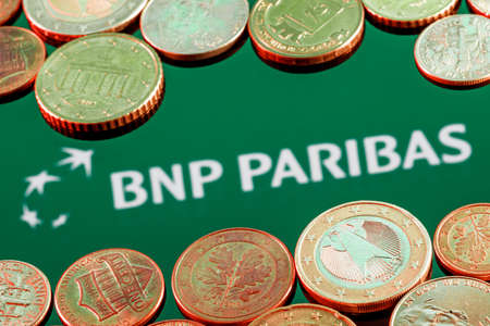 Kazan, Russia - Apr 27, 2022: Variety of metal coins on background of BNP Paribas bank logoのeditorial素材
