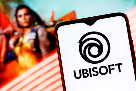Kazan, Russia - Apr 15, 2022: Ubisoft is French video game company. Ubisoft logo on smartphone screen. Frame from Far Cry 6 on background.のeditorial素材
