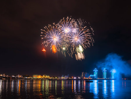 Fireworks over city with reflection in riverの写真素材