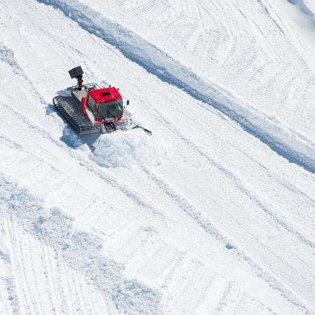 A Tractor woking on snow field preparing for skiの写真素材