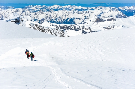A group of mountain hiker walking on the snow into the mountainの写真素材