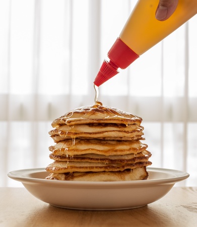 Pouring Honey onto Layers of pancakeの写真素材