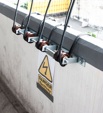 Electricity wire rolled with warning signの写真素材