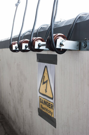 Electricity wire rolled with warning signの写真素材