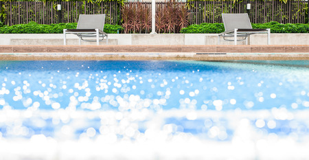 Relaxing pool chair by side of swimming poolの写真素材