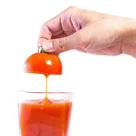 Fresh tomato juice pouring into glassの写真素材