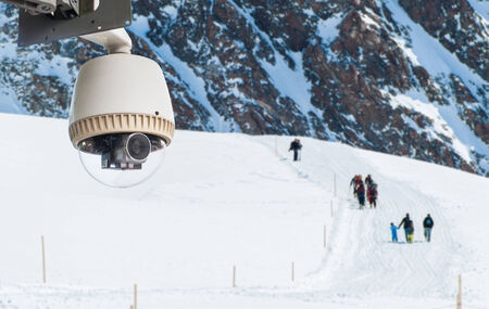 CCTV Camera or surveillance Operating in snow mountain with hikerの写真素材