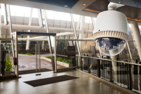 CCTV Camera operating in front of glass doorの写真素材