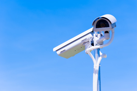 CCTV camera or surveillance operaiting on blue skyの写真素材