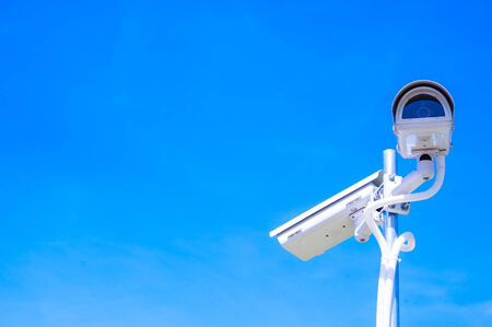 CCTV camera or surveillance operaiting on blue skyの写真素材