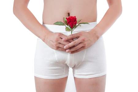 close up of man on white boxer underware  holding red rose isolate on white backgroundの写真素材