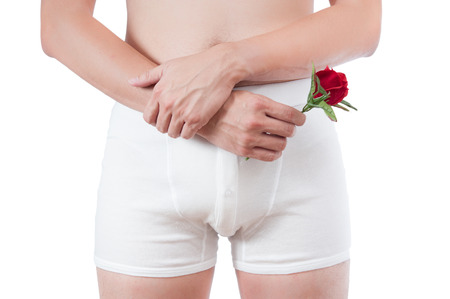 close up of man on white boxer underware  holding red rose isolate on white backgroundの写真素材