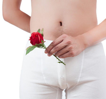 close up of man on white boxer underware  holding red rose isolate on white backgroundの写真素材