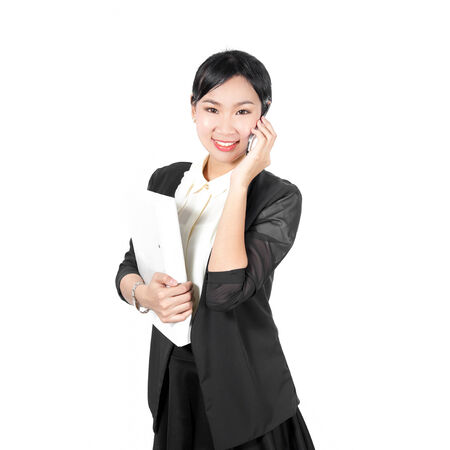 Young business woman holding white file using cell phoneの写真素材