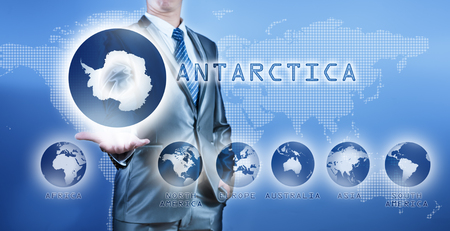 Businessman choosing antarctica continent on virtual digital screen, business concept of decision makingの写真素材
