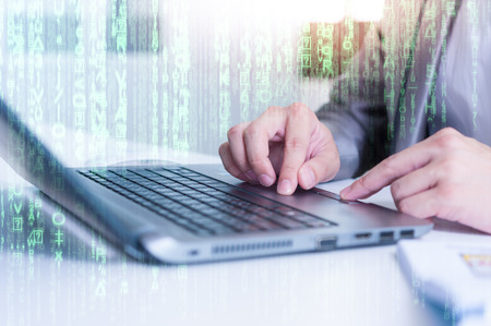 Close up of business man typing on laptop conputer with technology layer effectの写真素材