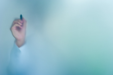 hand writing on blurred glass wall, abstract background with space editableの写真素材