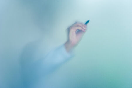 hand writing on blurred glass wall, abstract background with space editableの写真素材