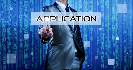 Business man with digital background pressing on button applicationの写真素材