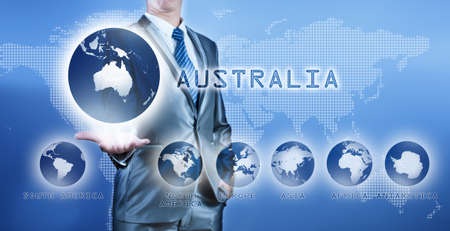 Businessman choosing australia continent on virtual digital screen, business concept of decision makingの写真素材
