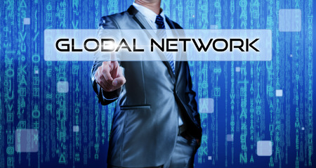 Business man with digital background pressing on button global networkの写真素材