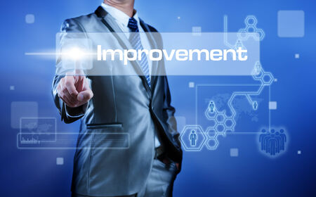 Business man with digital screen press on button improvementの写真素材