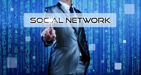 Business man with digital background pressing on button social networkの写真素材