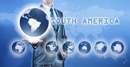 Businessman choosing south america continent on virtual digital screen, business concept of decision makingの写真素材