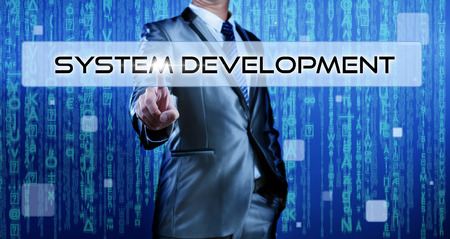 Business man with digital background pressing on button system developmentの写真素材