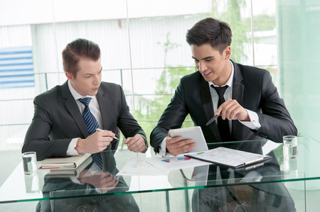 Two businessman using tablet in meetingの写真素材