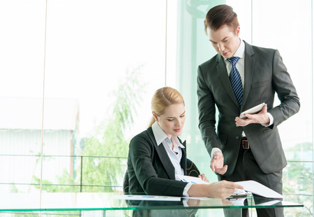 business partners discussing documents and ideas in officeの写真素材