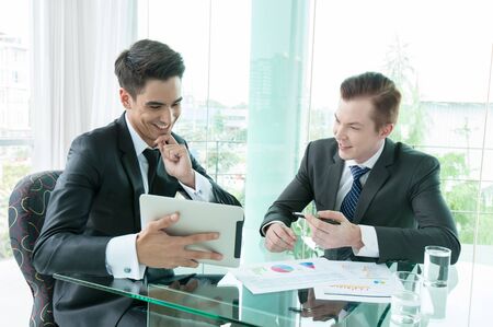 business partners discussing documents and ideas in officeの写真素材