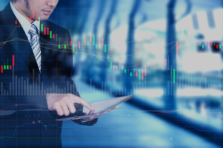 Businessman using tablet with technology layer effect, stock marketing conceptの写真素材