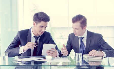 Two businessman using tablet in meetingの写真素材