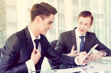 Two businessman using tablet in meetingの写真素材