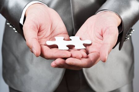 businessman show white jigsaw in hand, business strategy conceptの写真素材